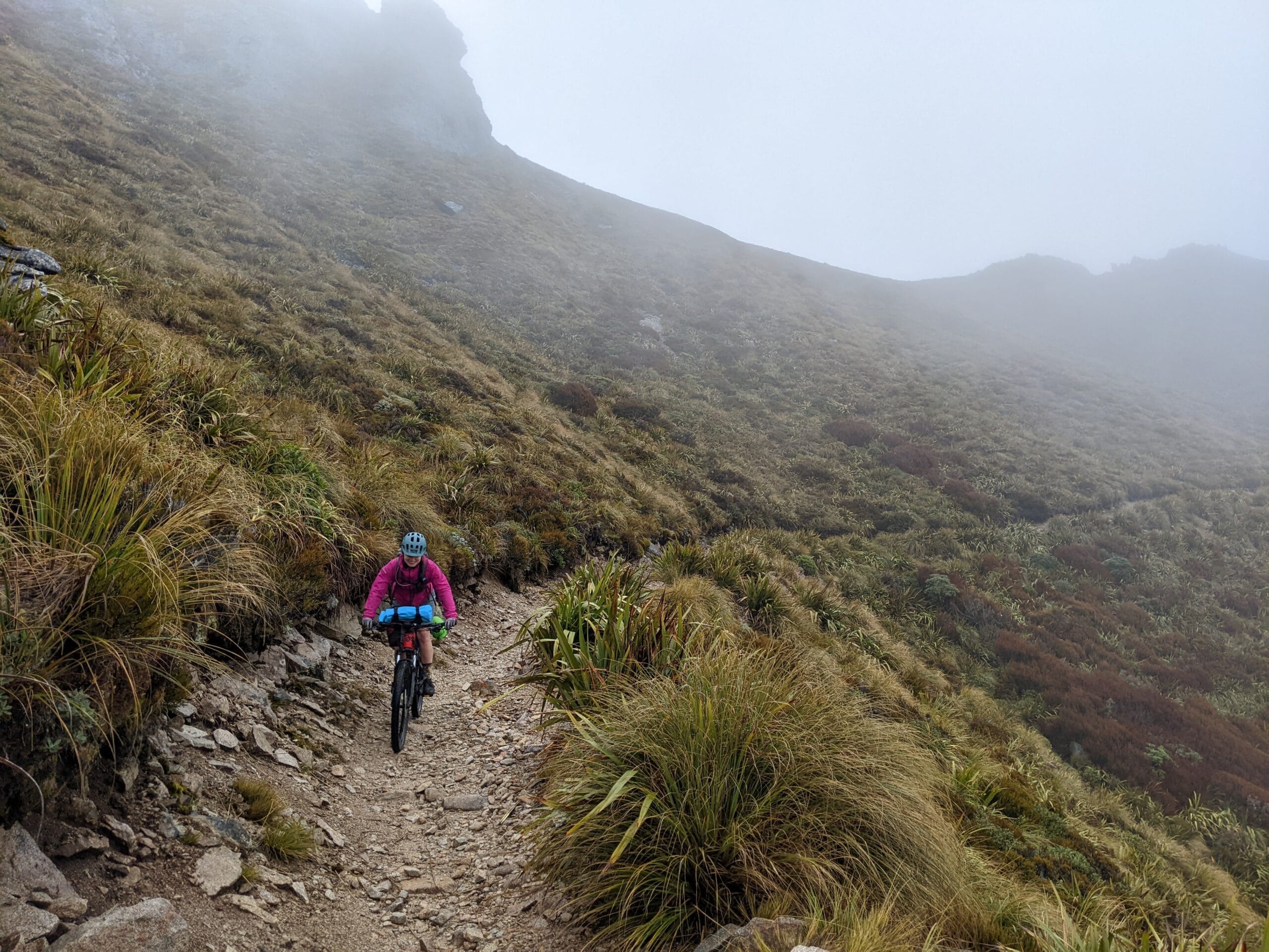 mountain bike rider in the clouds in New Zealand
