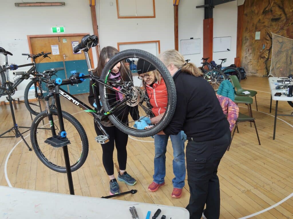 three women on bike mechanics course in christchurch